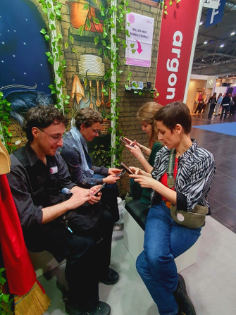 Vier Personen mit Handys am argon Stand