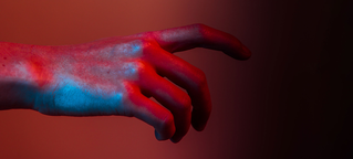 Bild einer Hand vor rotem Hintergrund
