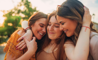 Drei Frauen in einer Umarmung und guter Laune