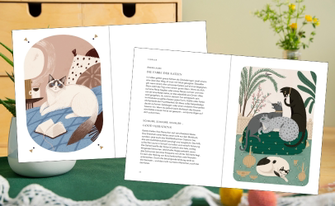 Schreibtisch im Hintergrund mit grünem Tischläufer und Pflanzen, im Vordergrund Innenseiten aus dem Buch mit Katzenillustrationen