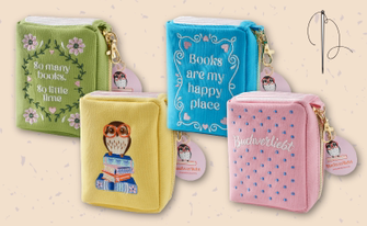4 verschiedene bestickte Täschchen mit Motiven und Sprüchen rund um das Thema "Bücherliebe", eine Sticknadel verweist nochmals auf den bestickten Charakter der Täschchen