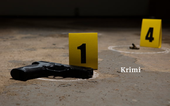Ein Tatort: Eine Waffe liegt auf dem Boden, gelbe Zahlenschilder stehen daneben.